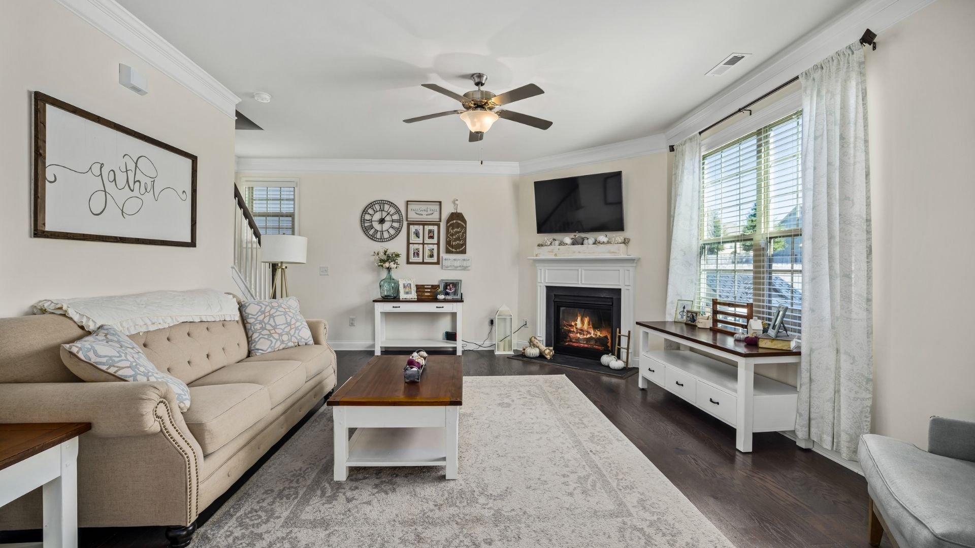 Cozy living room with fireplace, neutral decor, and farmhouse-style furnishings
