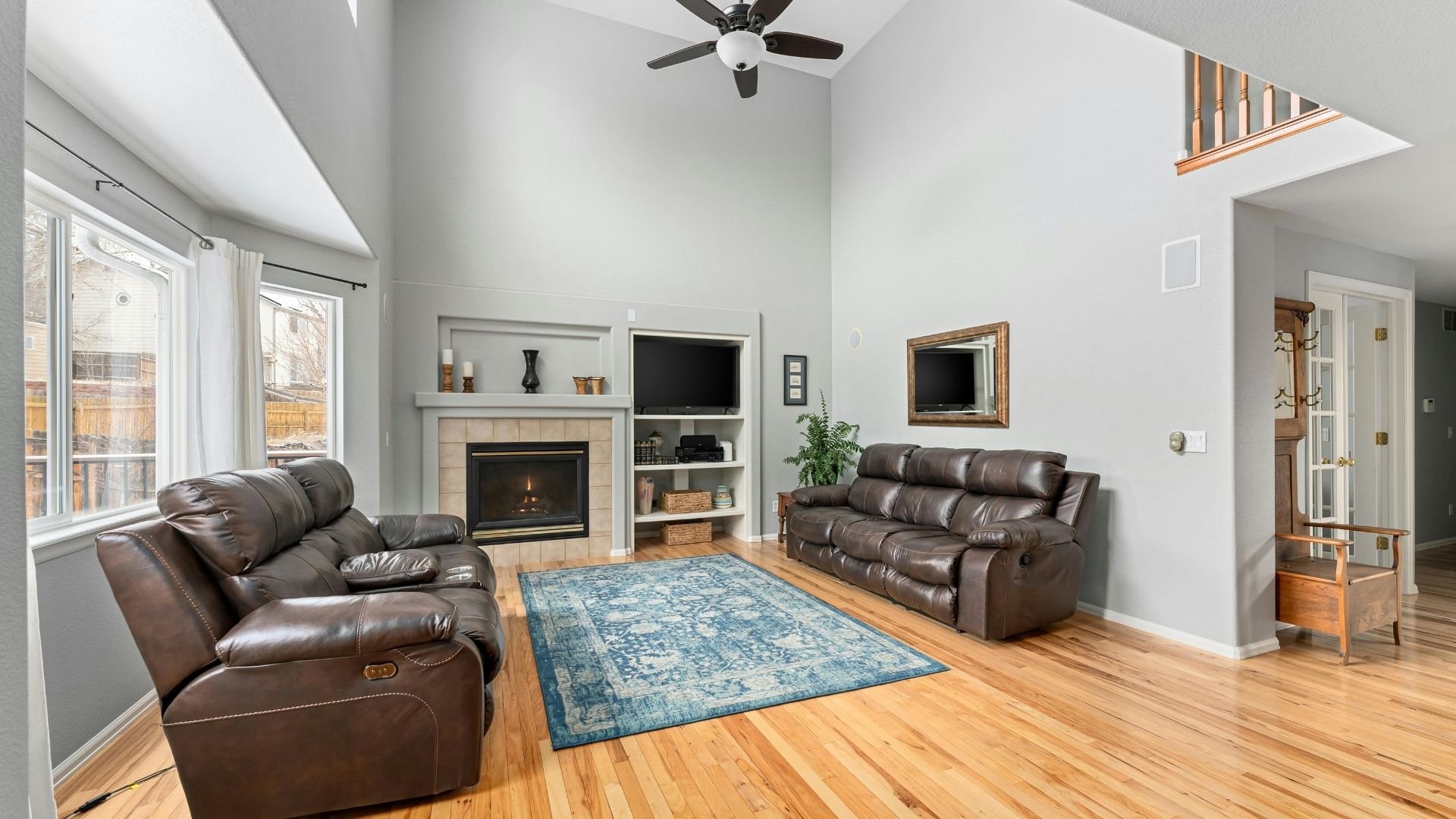Cozy living room with leather couches, fireplace, and blue area rug